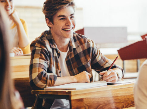 Teenage boy smiling during lecture in high school