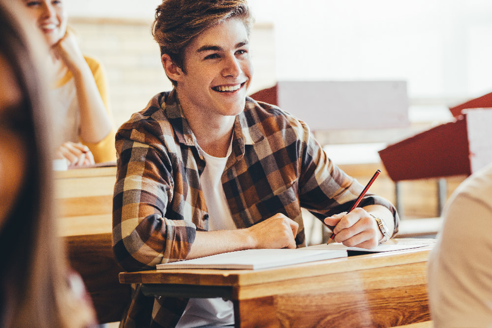 Teenage boy smiling during lecture in high school Teenage boy smiling during lecture in high school